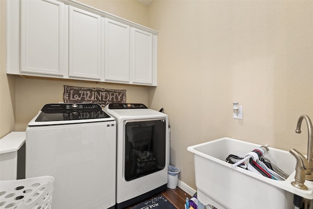 laundry area featuring cabinets, dark wood-type flooring, sink, and washer and dryer