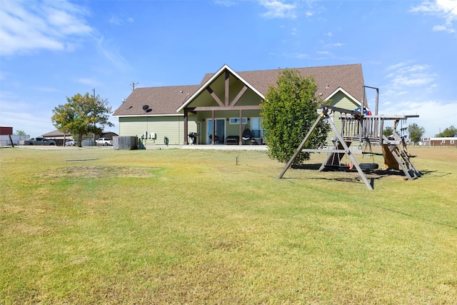 rear view of property with a lawn and a playground