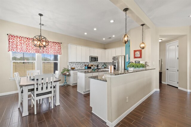 kitchen with stainless steel appliances, white cabinets, and dark wood-type flooring