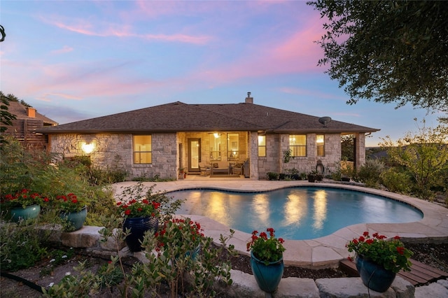 pool at dusk with a patio