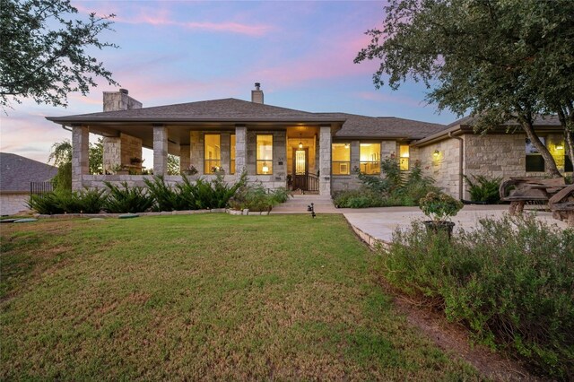 view of front of home with a porch and a yard