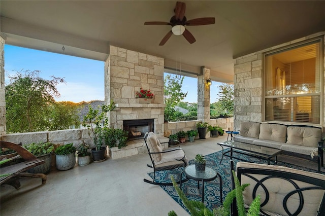 view of patio with an outdoor living space with a fireplace and a ceiling fan
