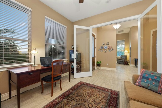 office space featuring french doors, light hardwood / wood-style flooring, and ceiling fan