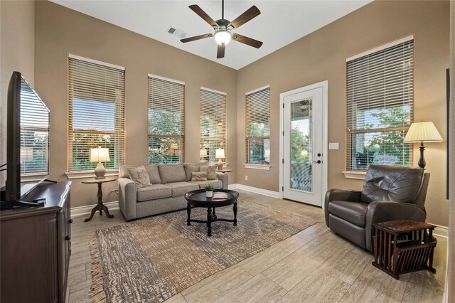 living room featuring ceiling fan and a wealth of natural light