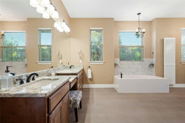 bathroom featuring a bath, tile patterned flooring, vanity, and a notable chandelier