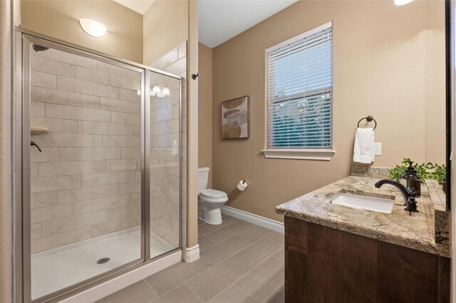 bathroom with walk in shower, vanity, tile patterned flooring, and toilet