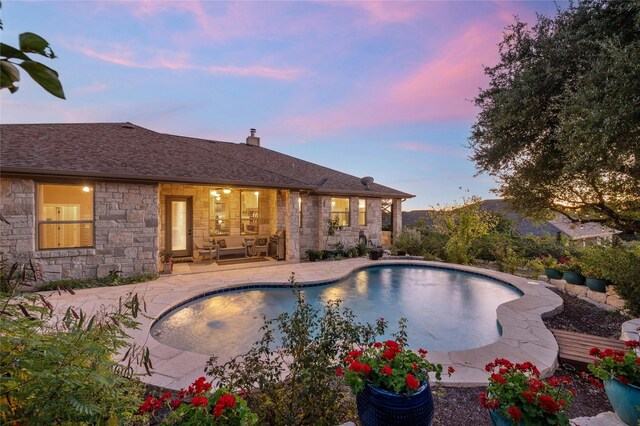 pool at dusk featuring a patio area