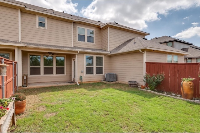 back of property featuring a lawn and ceiling fan