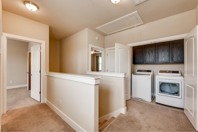 washroom featuring light colored carpet, cabinets, and washer and dryer