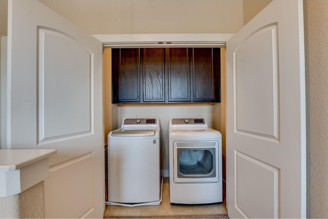 clothes washing area featuring cabinets and separate washer and dryer