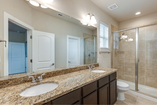 bathroom with vanity, a shower with shower door, toilet, and tile patterned floors