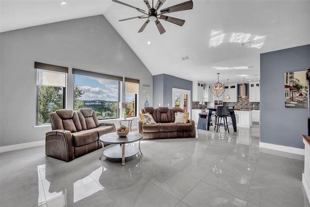 living room featuring ceiling fan with notable chandelier and high vaulted ceiling