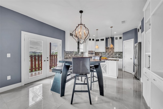 dining area with french doors and an inviting chandelier