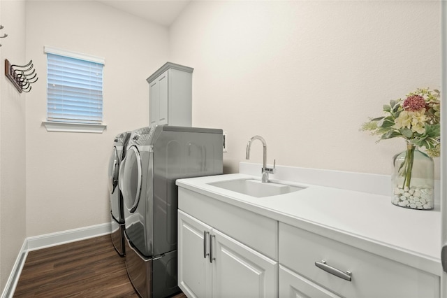 washroom featuring sink, washer and dryer, dark hardwood / wood-style flooring, and cabinets