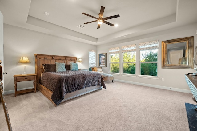 bedroom featuring a tray ceiling, ceiling fan, and light colored carpet