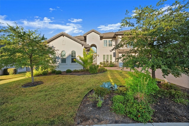 mediterranean / spanish house featuring a front yard