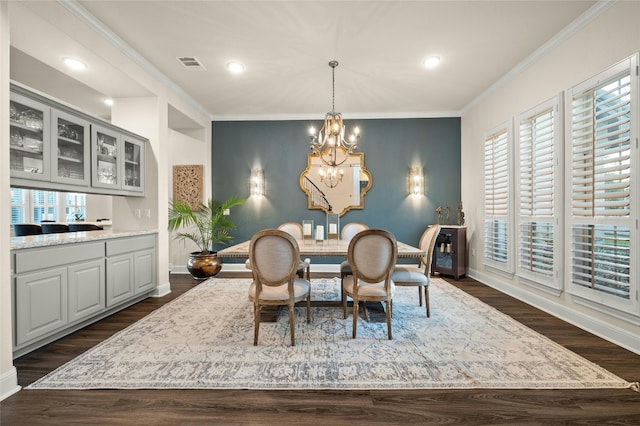 dining room with a notable chandelier, crown molding, and dark hardwood / wood-style flooring