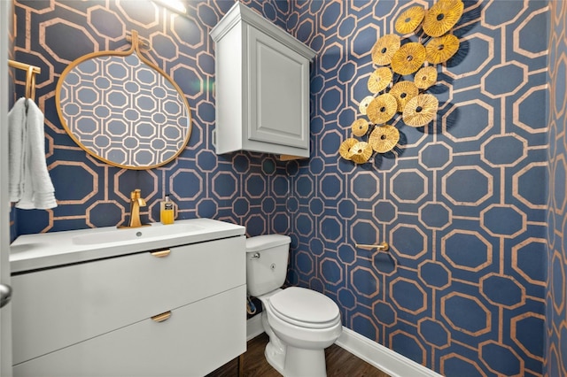 bathroom with vanity, toilet, and hardwood / wood-style flooring