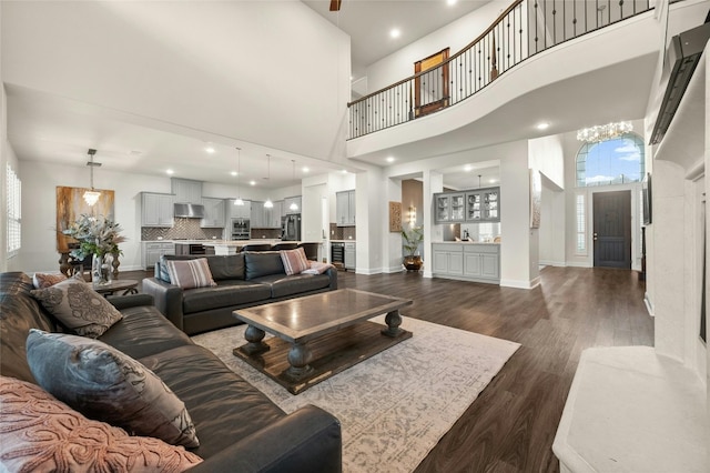 living room with a notable chandelier, a high ceiling, and dark hardwood / wood-style flooring