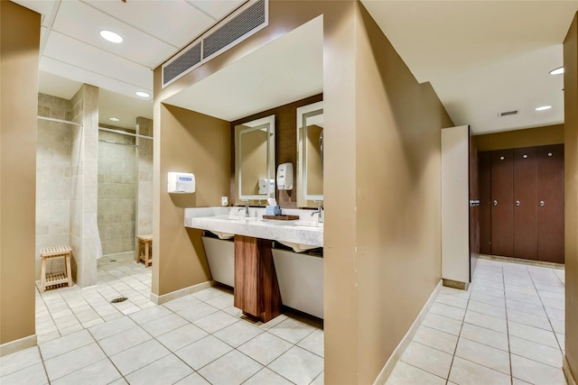 bathroom with tile patterned flooring, a shower with door, and vanity