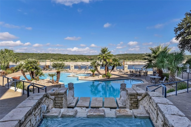 view of pool featuring a patio and a water view