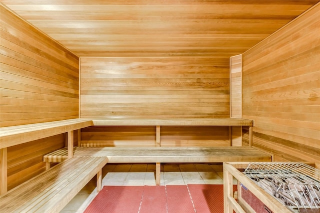 view of sauna / steam room featuring wood ceiling and wooden walls