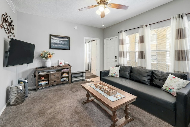 living room with a textured ceiling, carpet, and ceiling fan