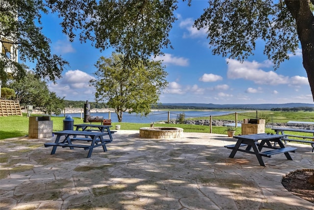 view of community with a lawn, a patio, and a water and mountain view