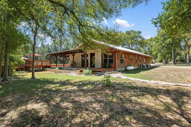 exterior space featuring a front lawn and a wooden deck