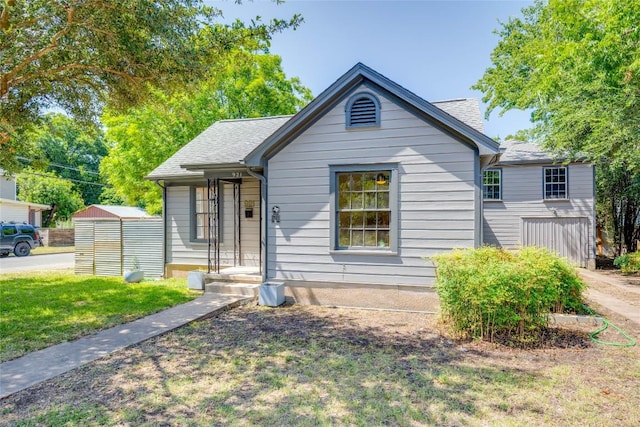 view of front of home featuring a shingled roof and a front lawn