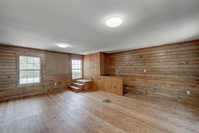 empty room featuring wood walls and light wood-style flooring