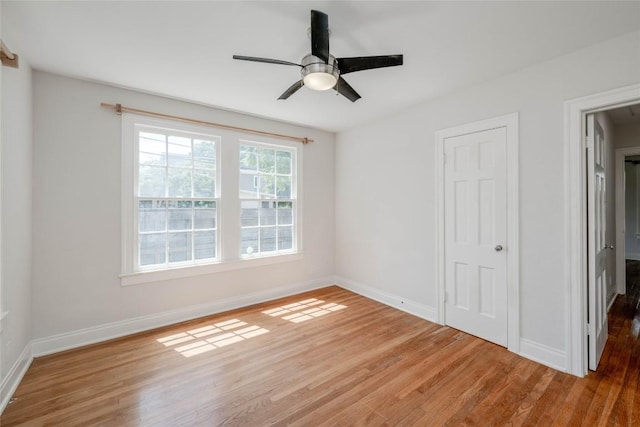 spare room featuring ceiling fan, baseboards, and wood finished floors