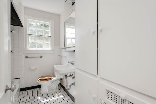 full bathroom featuring a wainscoted wall, shower / bath combination, toilet, and tile walls