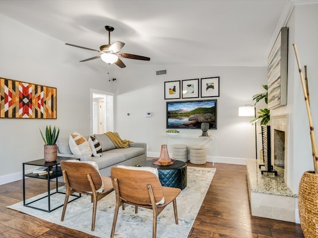 living room featuring a high end fireplace, lofted ceiling, ceiling fan, and dark wood-type flooring