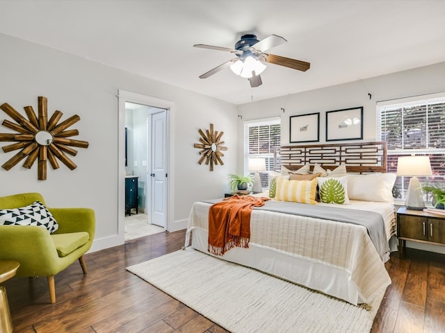 bedroom with ceiling fan, connected bathroom, and dark wood-type flooring