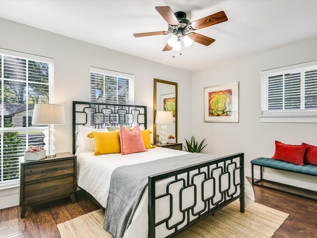 bedroom with multiple windows, dark hardwood / wood-style floors, and ceiling fan