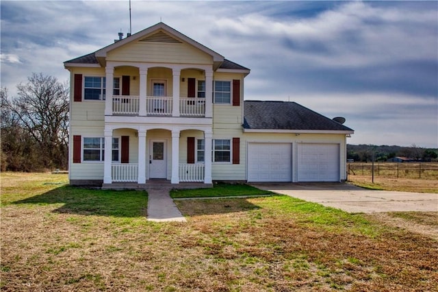 view of front of property featuring a balcony, covered porch, a front yard, and a garage