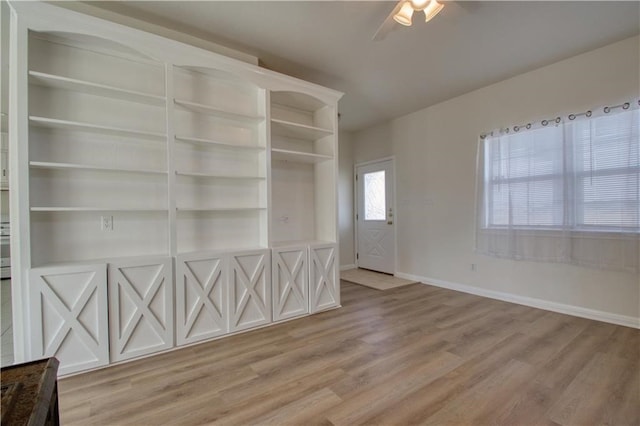 spare room with built in shelves, ceiling fan, and hardwood / wood-style flooring