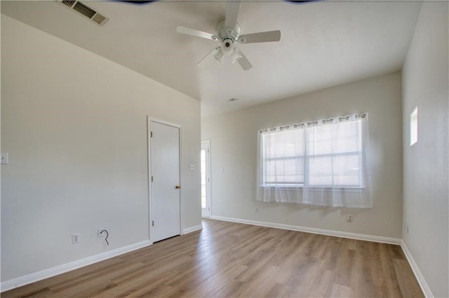 empty room with ceiling fan and light hardwood / wood-style flooring