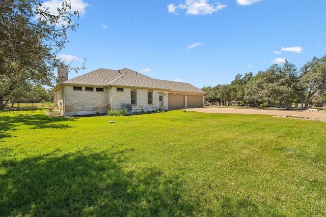 back of property with a garage and a lawn