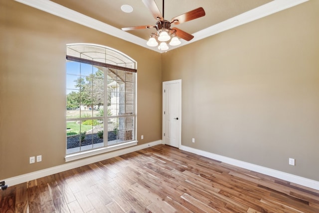 empty room featuring crown molding, light wood-type flooring, and ceiling fan