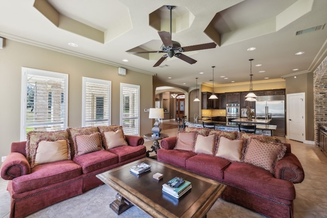 living room featuring ceiling fan, ornamental molding, and light tile patterned flooring