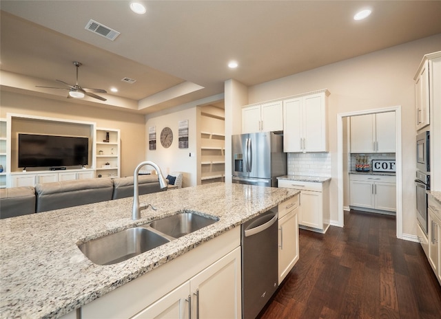 kitchen with light stone countertops, stainless steel appliances, dark wood-type flooring, and sink