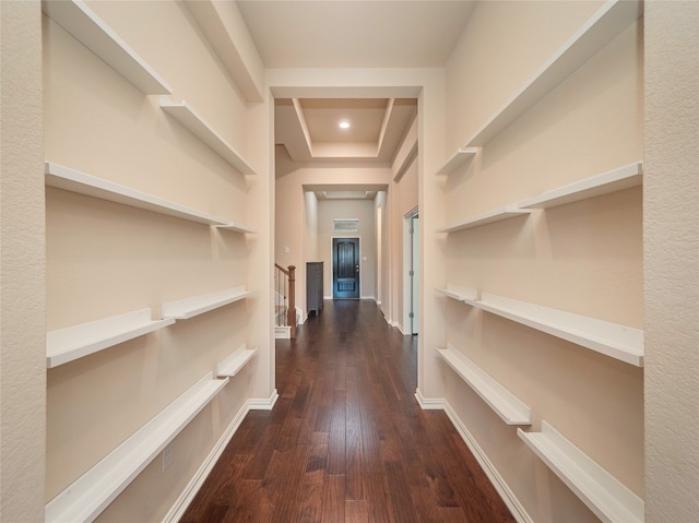 corridor featuring a raised ceiling and dark hardwood / wood-style flooring