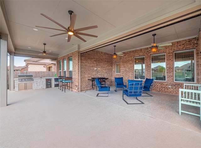 view of patio / terrace featuring a grill, ceiling fan, and an outdoor kitchen