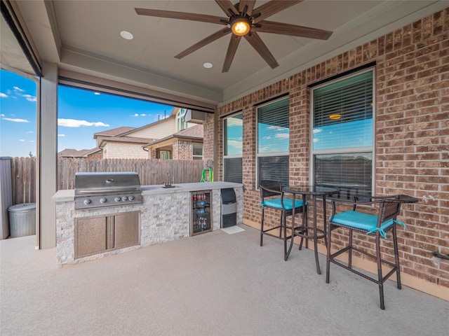 view of patio featuring grilling area, sink, ceiling fan, and an outdoor kitchen