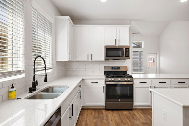 kitchen featuring light hardwood / wood-style flooring, white cabinets, appliances with stainless steel finishes, and sink