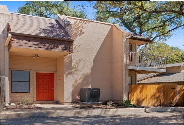 view of exterior entry featuring a balcony and cooling unit