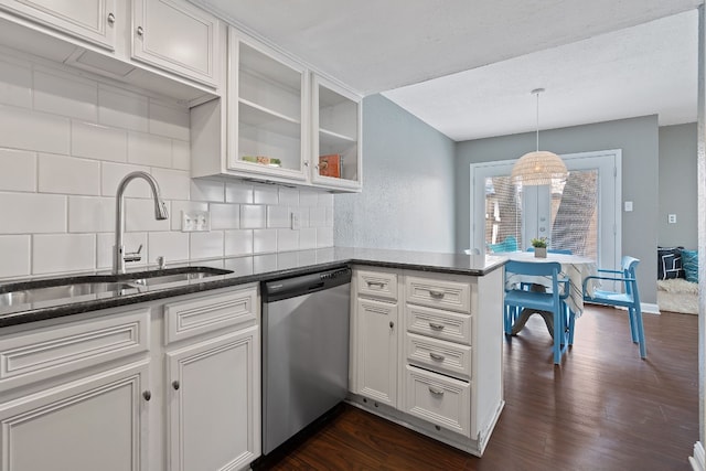 kitchen with backsplash, stainless steel dishwasher, sink, white cabinetry, and hanging light fixtures