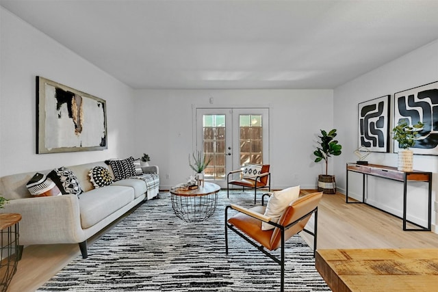 living room with french doors, light wood-style flooring, and baseboards